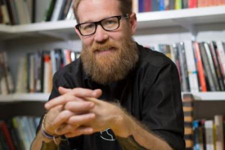 Dr. Heynen poses in front of a bookcase